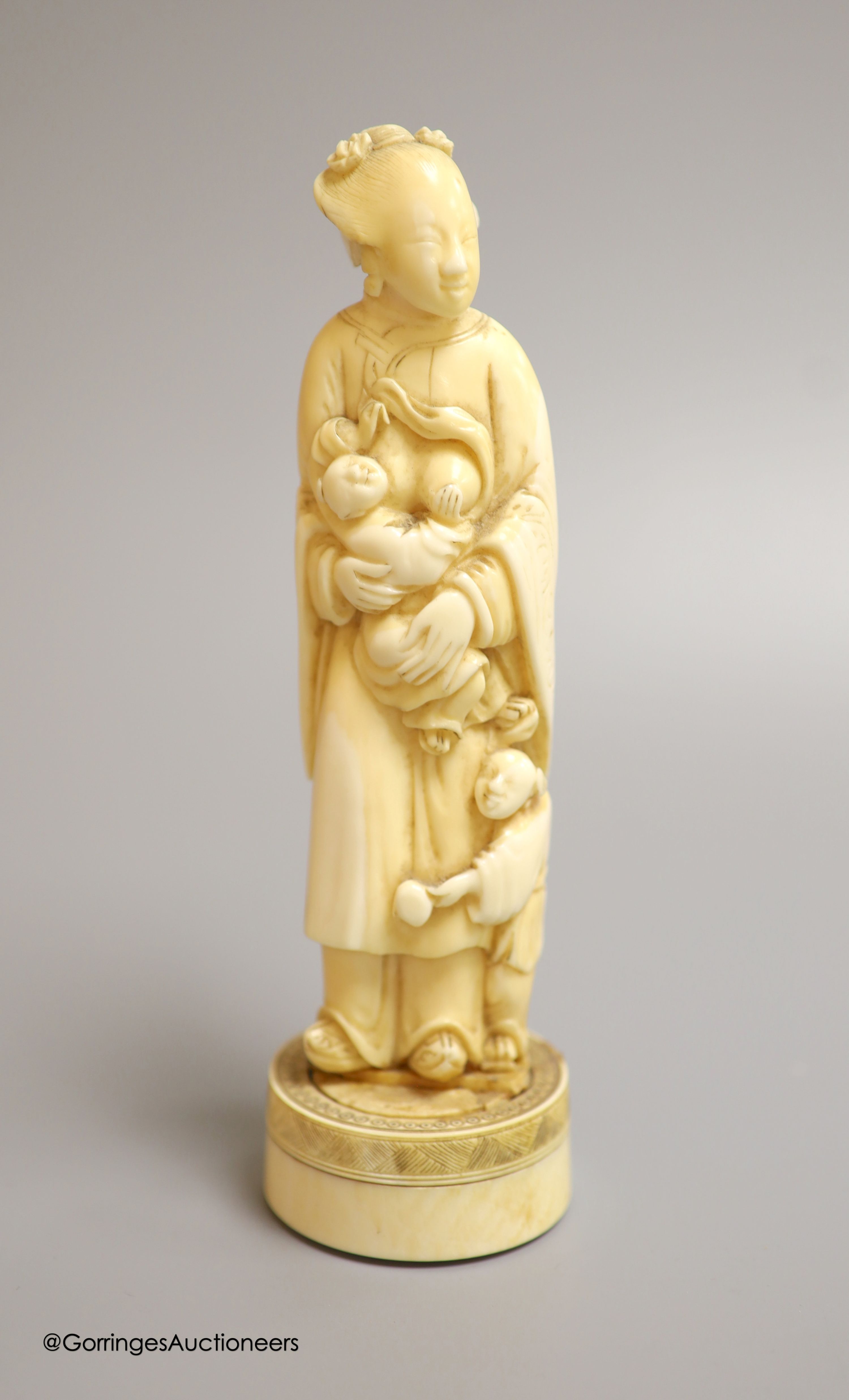 A Japanese ivory okimono of a lady feeding a child, Meiji period, height 18cm